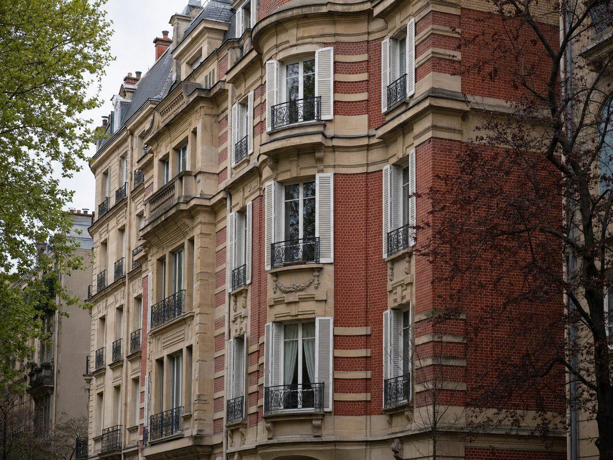 Immeuble de Neuilly-sur-Seine du début du XXe siècle en pierre de taille et brique rouge, bow-windows et volets bois peints en blanc, avenue plantée d'arbres